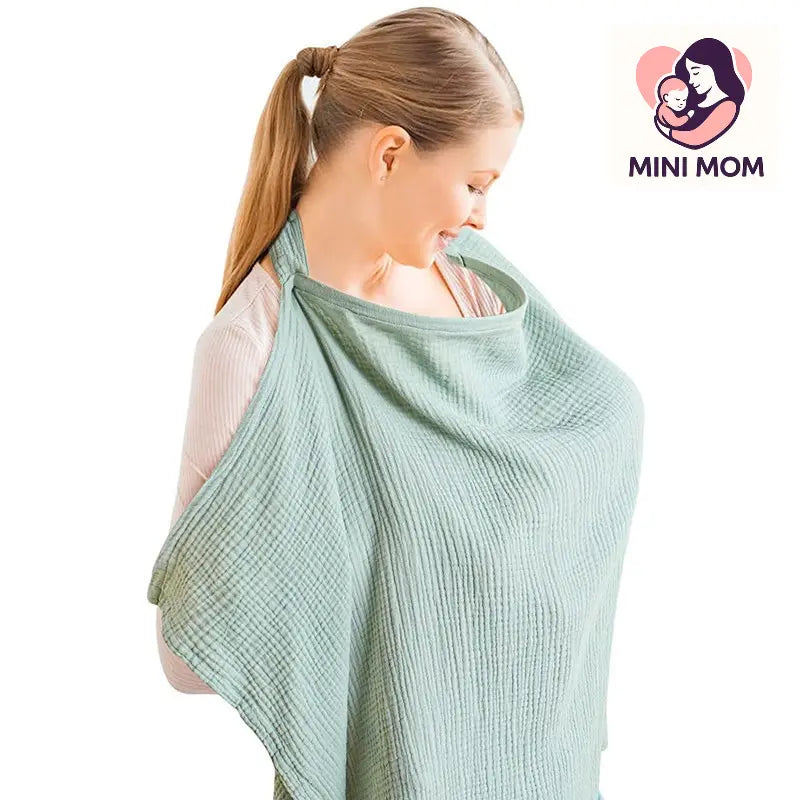 Woman using a green baby carrier with 'Mini Mom' logo in the corner.