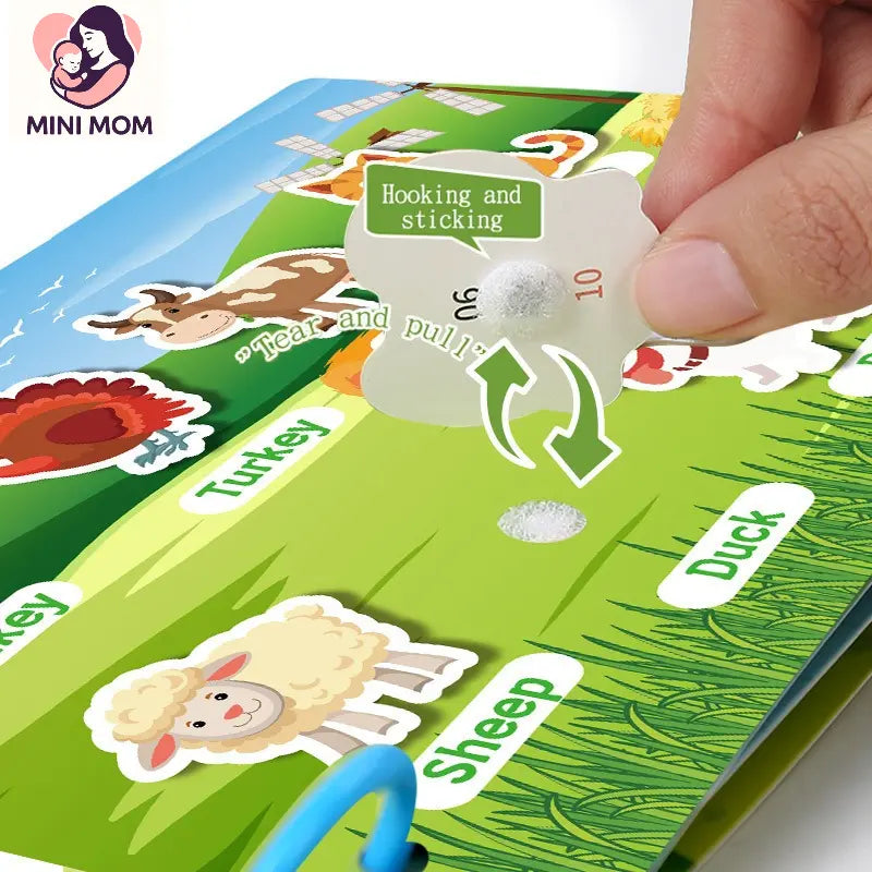 Children's educational game with stickers and a hand interacting with it, featuring the brand 'MINI MOM'.