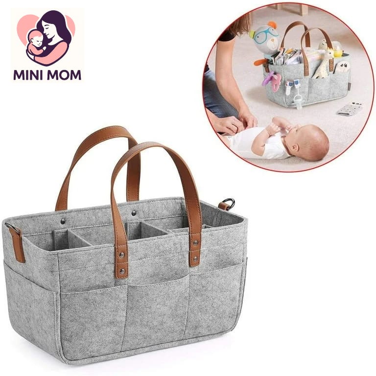 Gray baby organizer with brown handles and a Mini Mom logo, inset showing a baby being cared for.