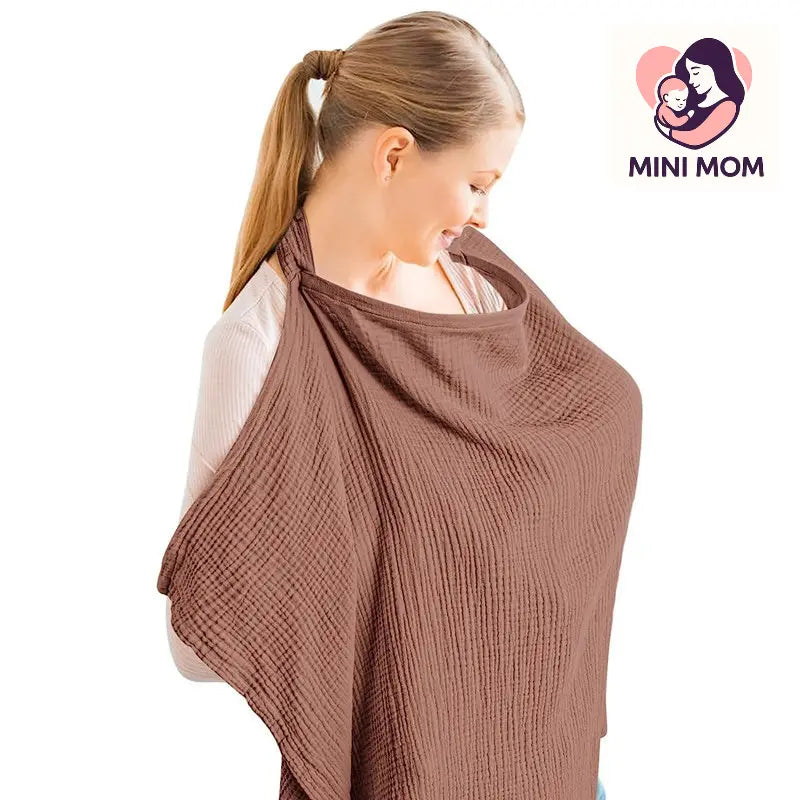 Woman wearing a brown baby breastfeeding nursing cover with 'Mini Mom' logo in the corner
