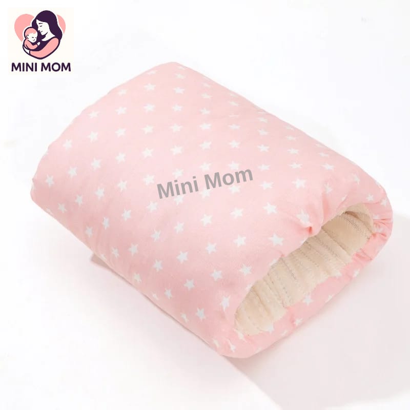Pink polka dot breastfeeding pillow with 'Mini Mom' text on a white background, featuring the Mini Mom brand logo.