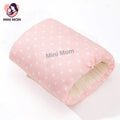 Pink polka dot breastfeeding pillow with 'Mini Mom' text on a white background, featuring the Mini Mom brand logo.